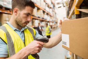 Close,Up,Of,Warehouse,Worker,Scanning,Barcodes,On,Boxes,In