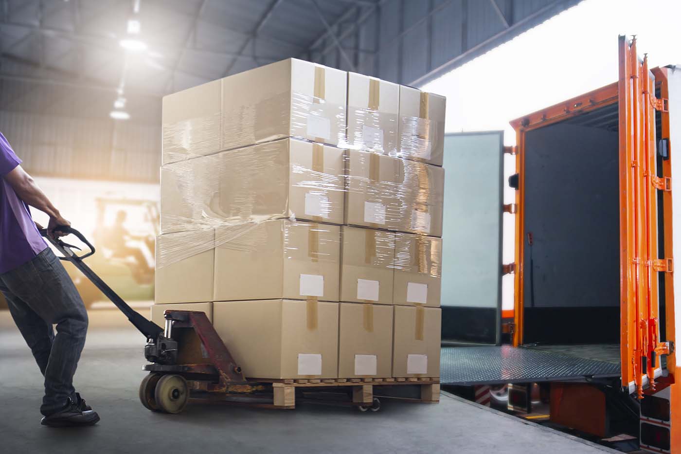 Worker Courier Unloading Package Box Out Of Cargo Container. Delivery service. Truck Loading at Dock Warehouse. Shipments. Shipping Warehouse Logistics and Transportation.
